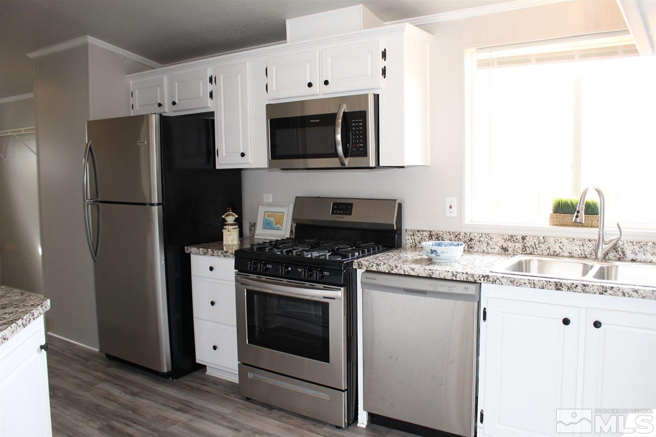 5189 Coggins Road Reno, NV 89506 - Photo 10 of 33 a kitchen with stainless steel appliances a white stove top oven and a refrigerator