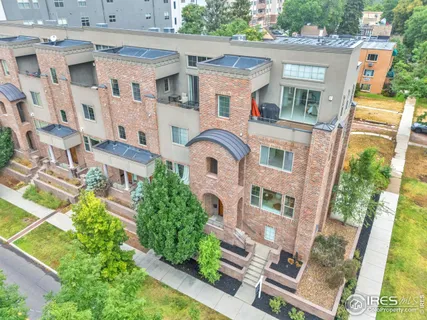 an aerial view of residential houses with outdoor space and parking