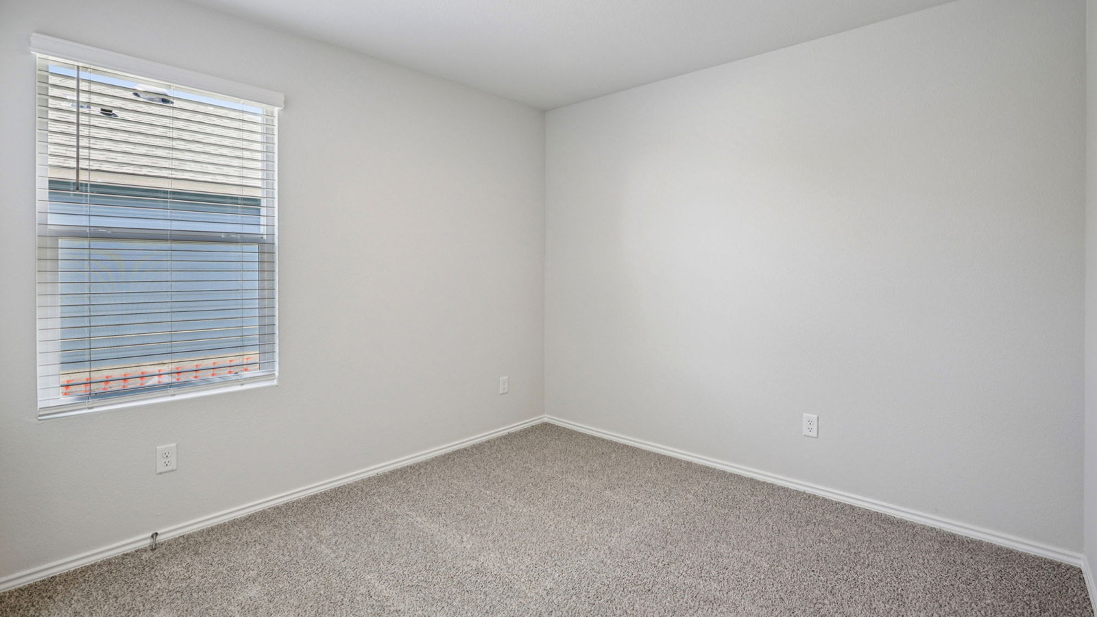 156 Wyatt Way Jarrell, TX 76537 - Photo 23 of 30 Neutral white walls with matching trim, featuring a single window with horizontal blinds and a textured carpeted floor