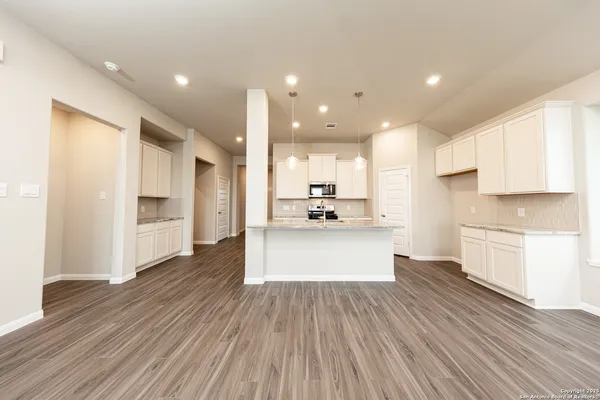 a view of kitchen view wooden floor stainless steel appliances and cabinets