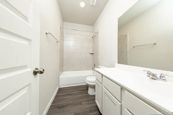 a bathroom with a sink a toilet a shower and a mirror