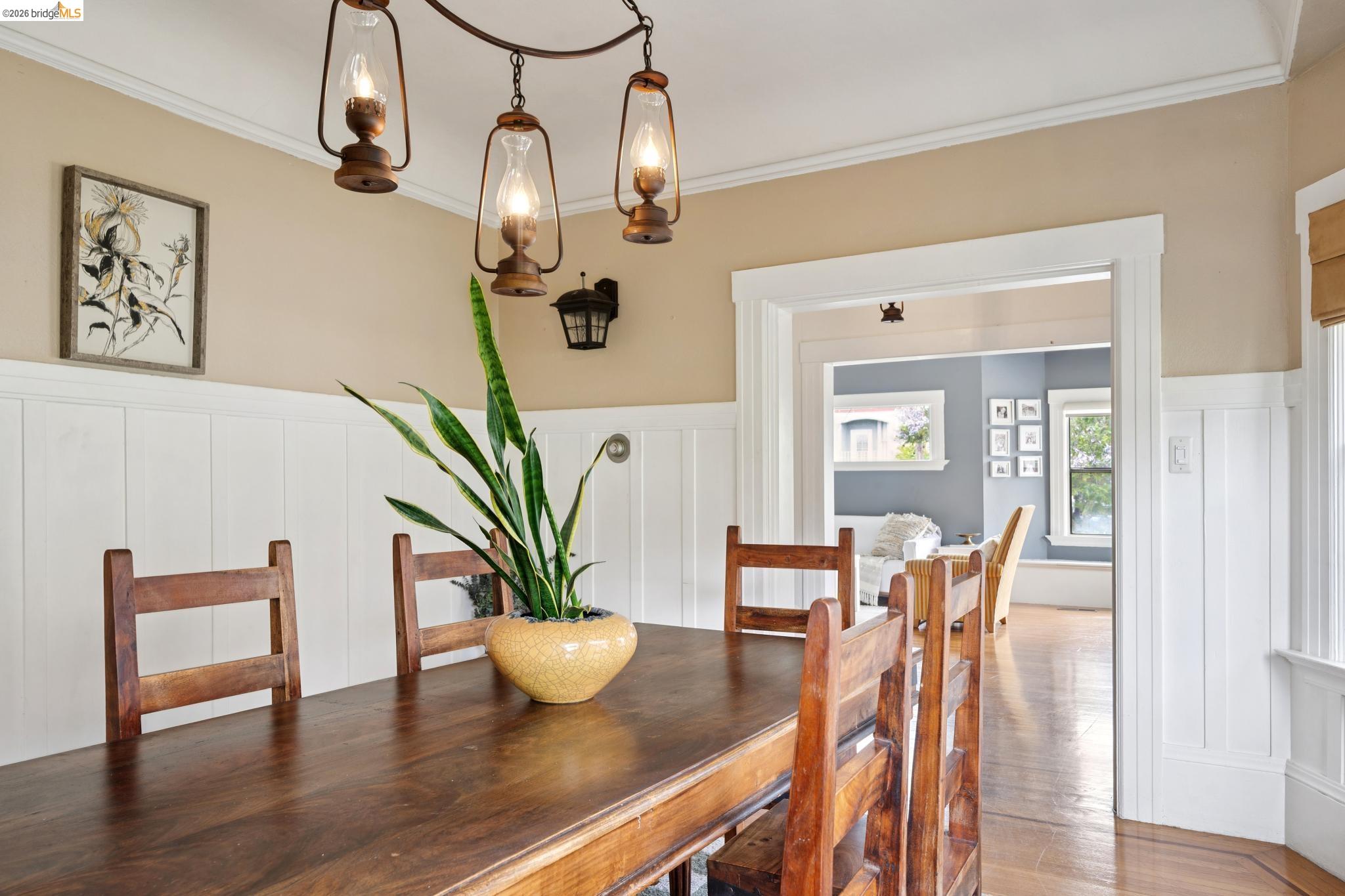 892 Laurel Street Alameda, CA 94501 - Photo 14 of 45 Dining area featuring a three-light lantern chandelier, chair rail with wainscoting, and wood-finish flooring