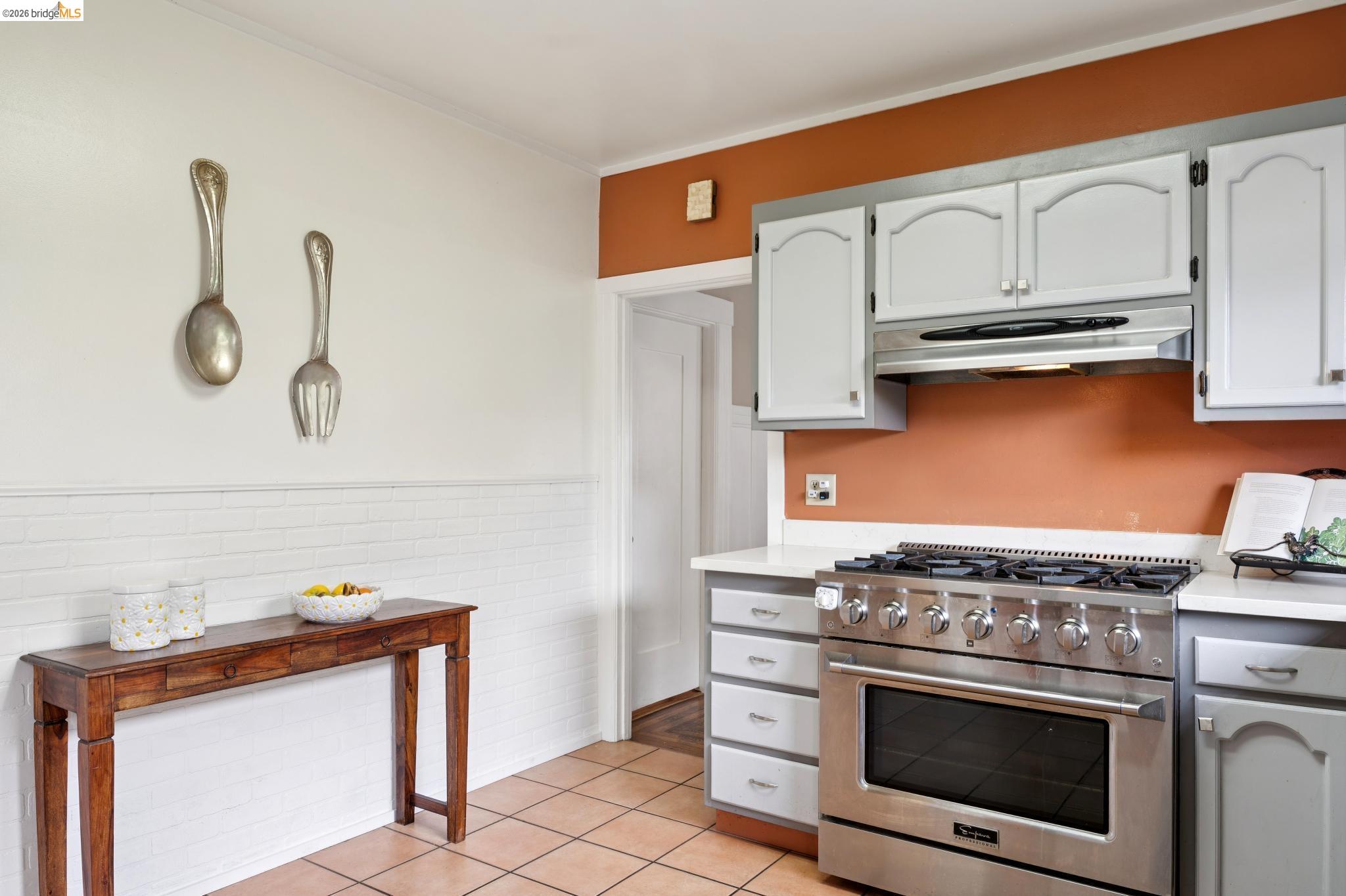 892 Laurel Street Alameda, CA 94501 - Photo 22 of 45 Kitchen featuring a stainless steel gas range with an oven, light-colored upper and lower cabinetry, white countertops, and terracotta-toned floor tiles
