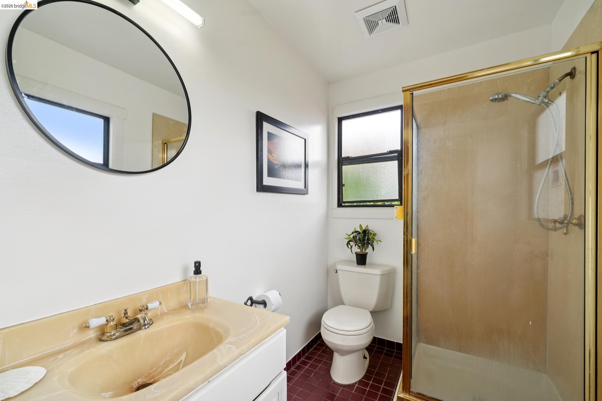 892 Laurel Street Alameda, CA 94501 - Photo 34 of 45 Bathroom featuring a vanity with an integrated sink, a large wall-mounted mirror, a framed shower enclosure, two windows, and maroon tile flooring