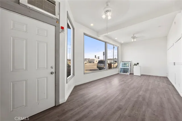 a view of a livingroom with wooden floor and furniture