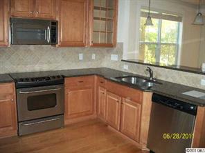 557 Jetton Street Davidson, NC 28036 - Photo 6 of 16 a kitchen with granite countertop a stove sink and cabinets