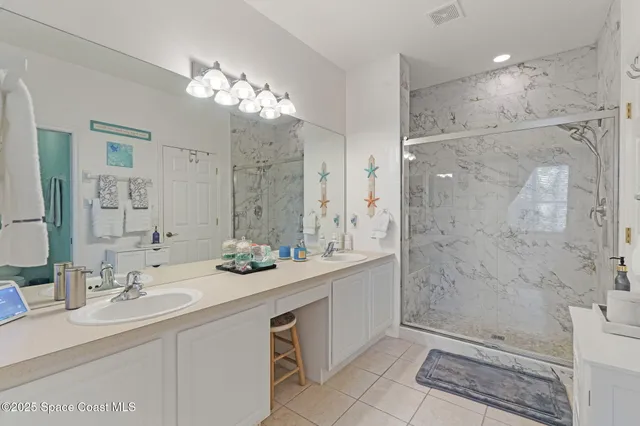 a bathroom with a sink a toilet a large mirror and shower