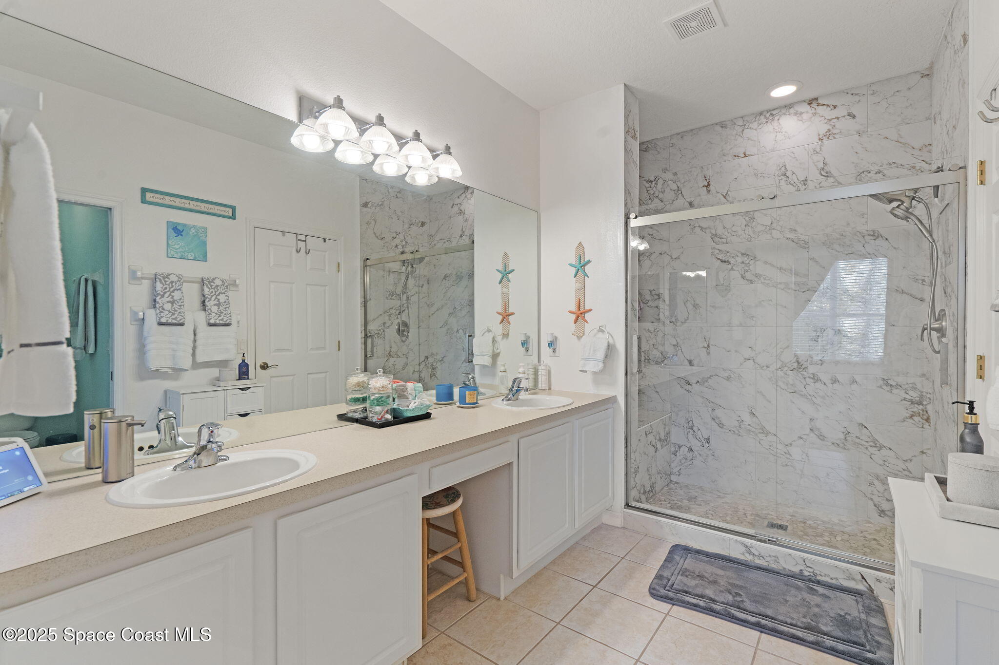 401 Trotter Lane, Unit 202 Melbourne, FL 32940 - Photo 12 of 38 a bathroom with a sink a toilet a large mirror and shower