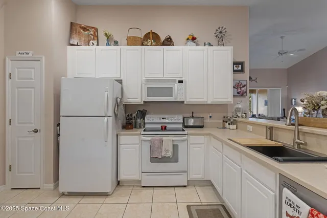 a kitchen with stainless steel appliances granite countertop white refrigerator sink and cabinets