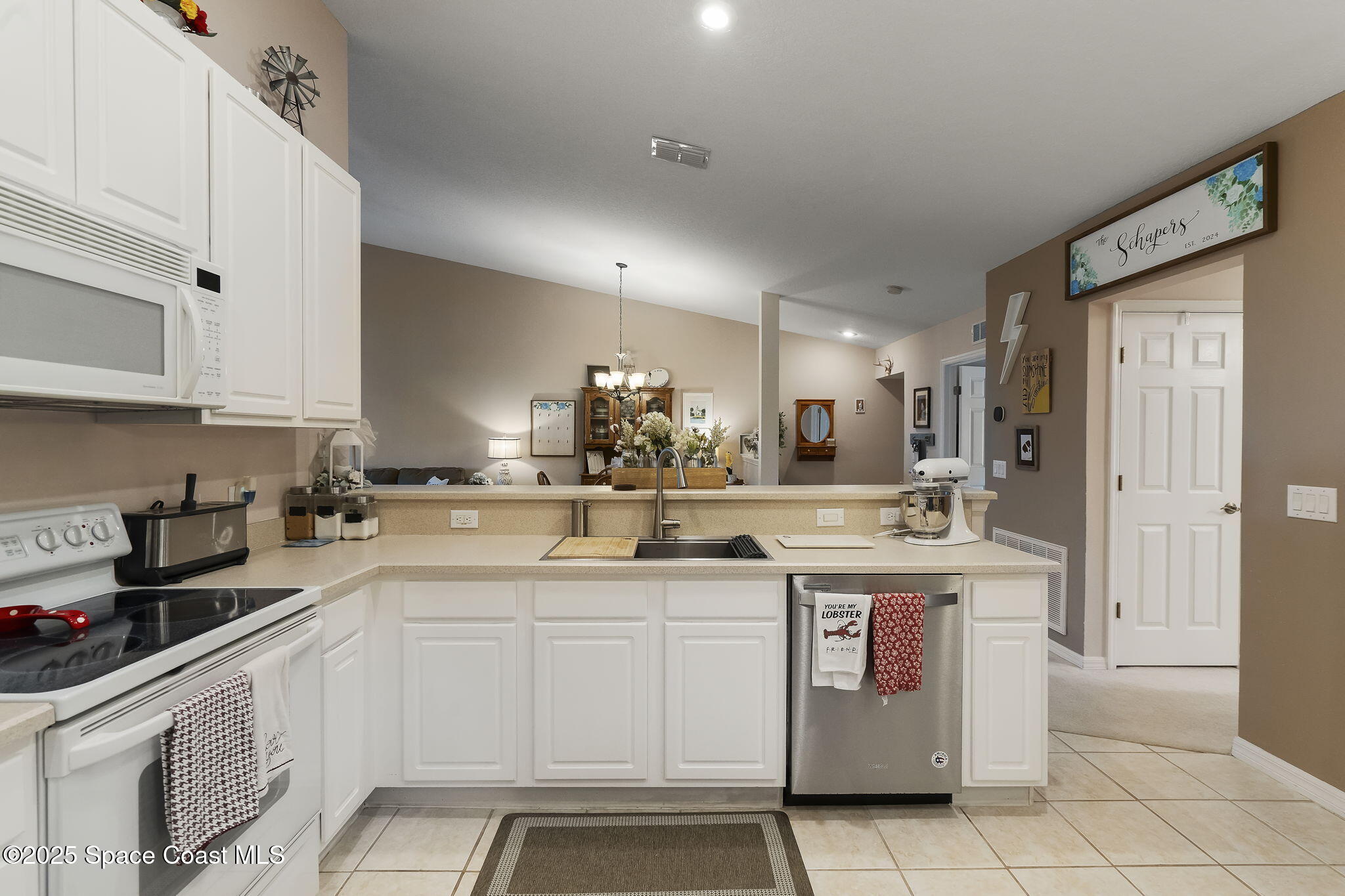 401 Trotter Lane, Unit 202 Melbourne, FL 32940 - Photo 26 of 38 a kitchen with a sink counter top space cabinets and stainless steel appliances