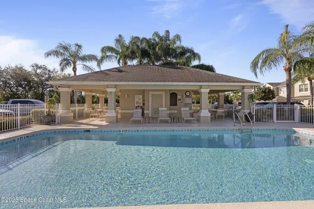 a view of a patio with table and chairs potted plants and palm tree