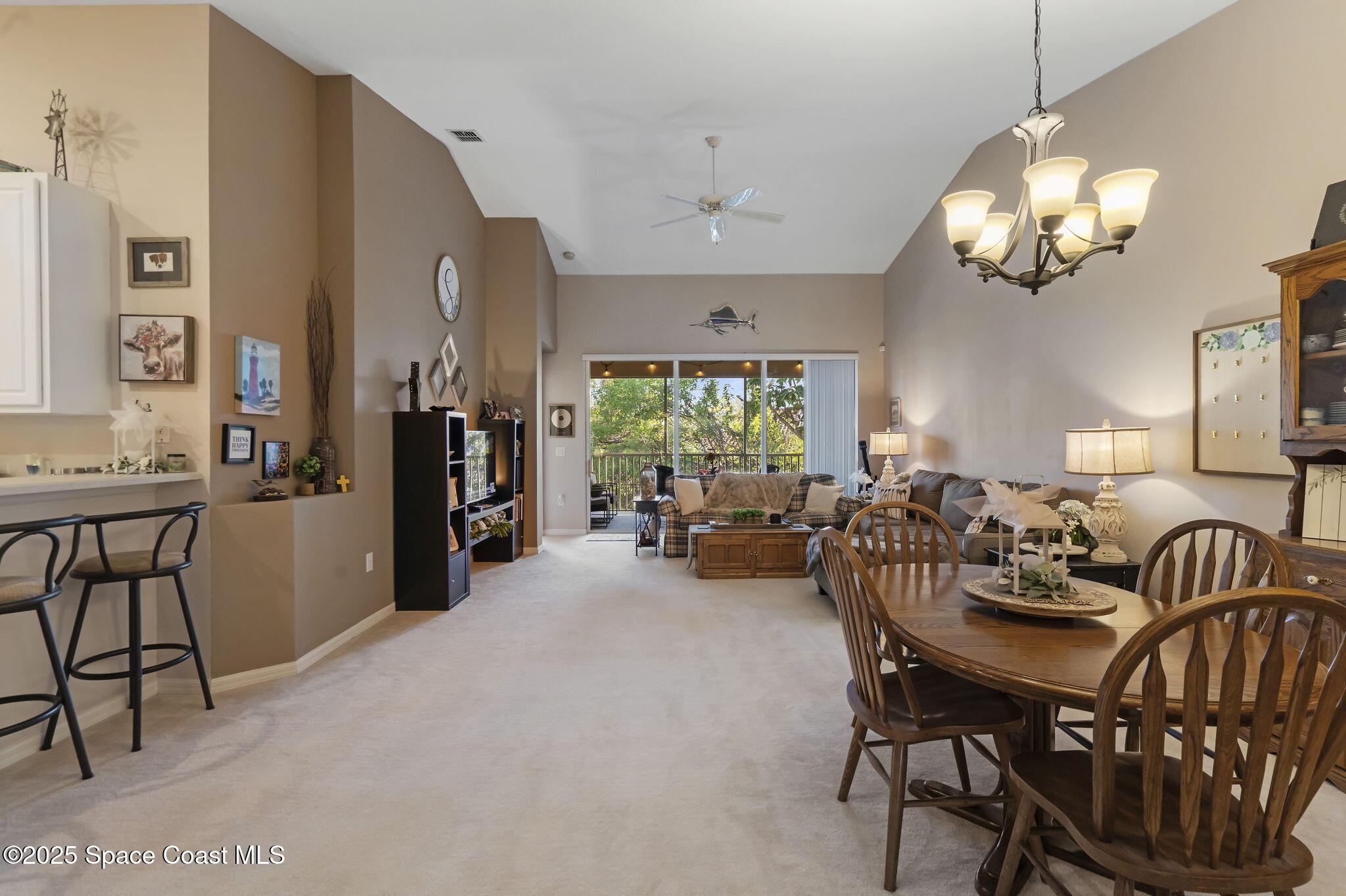 401 Trotter Lane, Unit 202 Melbourne, FL 32940 - Photo 4 of 38 a view of a dining room with furniture and a chandelier