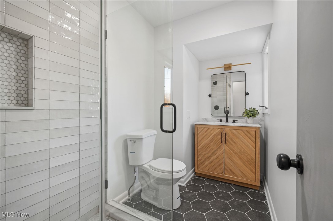 15857 Henley Road Cleveland, OH 44112 - Photo 8 of 42 Bathroom featuring vanity, tile patterned flooring, toilet, and a shower with door