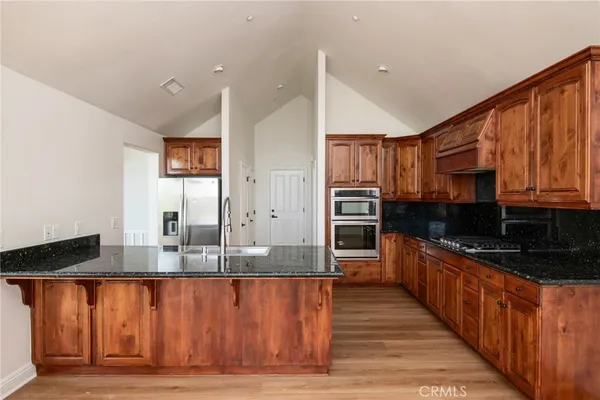a kitchen with stainless steel appliances granite countertop a stove a sink and a refrigerator