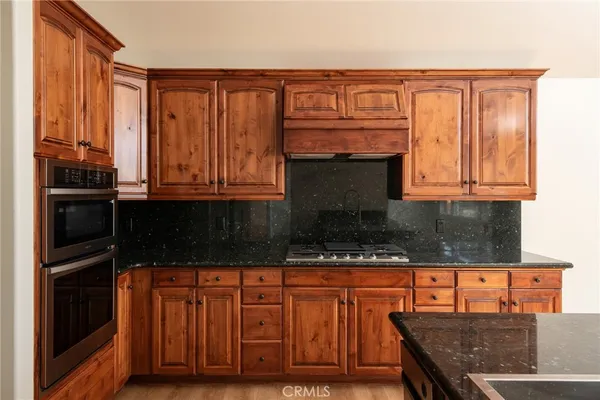 a kitchen with stainless steel appliances granite countertop a stove top oven microwave and cabinets