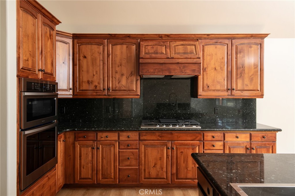 1477 Sequoia Drive Lake Arrowhead, CA 92352 - Photo 7 of 25 a kitchen with stainless steel appliances granite countertop a stove top oven microwave and cabinets