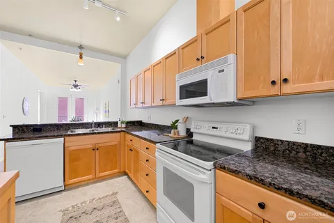 a kitchen with stainless steel appliances granite countertop a sink stove and microwave