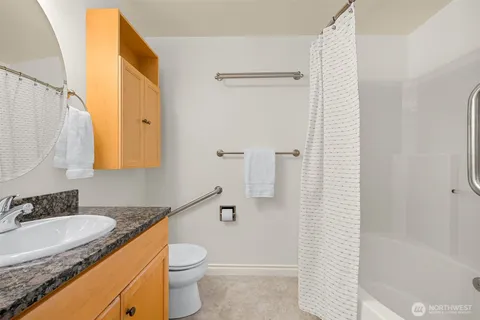 a bathroom with a granite countertop sink toilet and shower