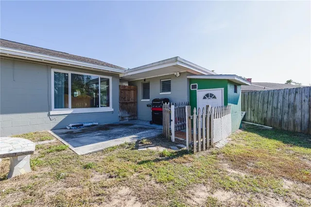 a view of a house with backyard and sitting area