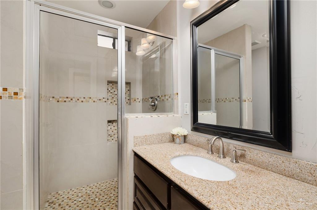 2507 East Mile 5 Road Mission, TX 78573 - Photo 24 of 34 a bathroom with a granite countertop sink mirror and a shower