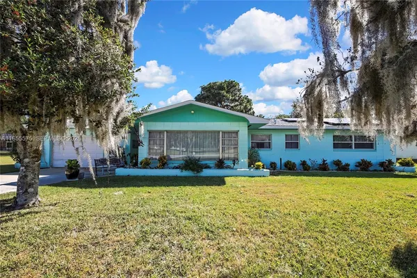a view of a house with a yard and swimming pool