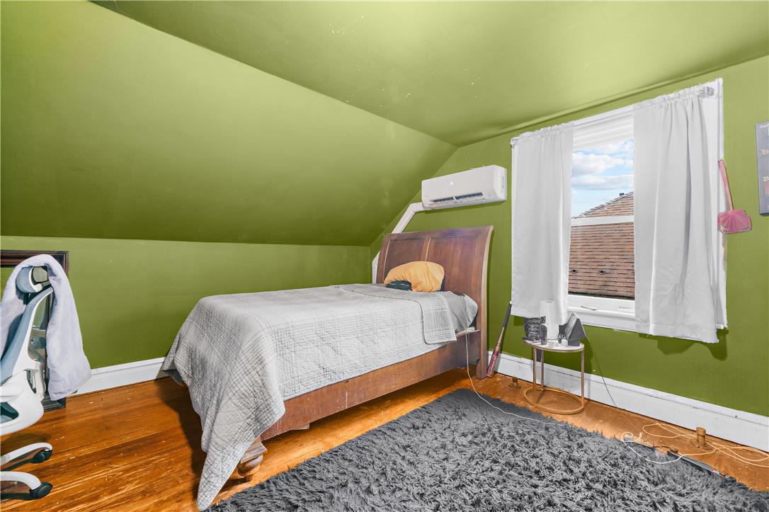 2055 Ferry Street Wilson, PA 18042 - Photo 19 of 21 This cozy bedroom features a unique sloped ceiling, hardwood flooring, and a bright window.