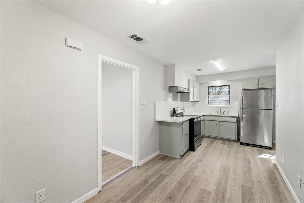1406 Ridgeview Street Mesquite, TX 75149 - Photo 6 of 16 a kitchen with a refrigerator and white cabinets