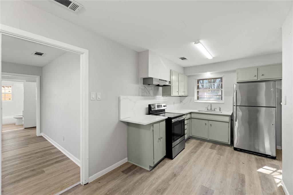 1406 Ridgeview Street Mesquite, TX 75149 - Photo 7 of 16 a kitchen with a sink a refrigerator and wooden floor