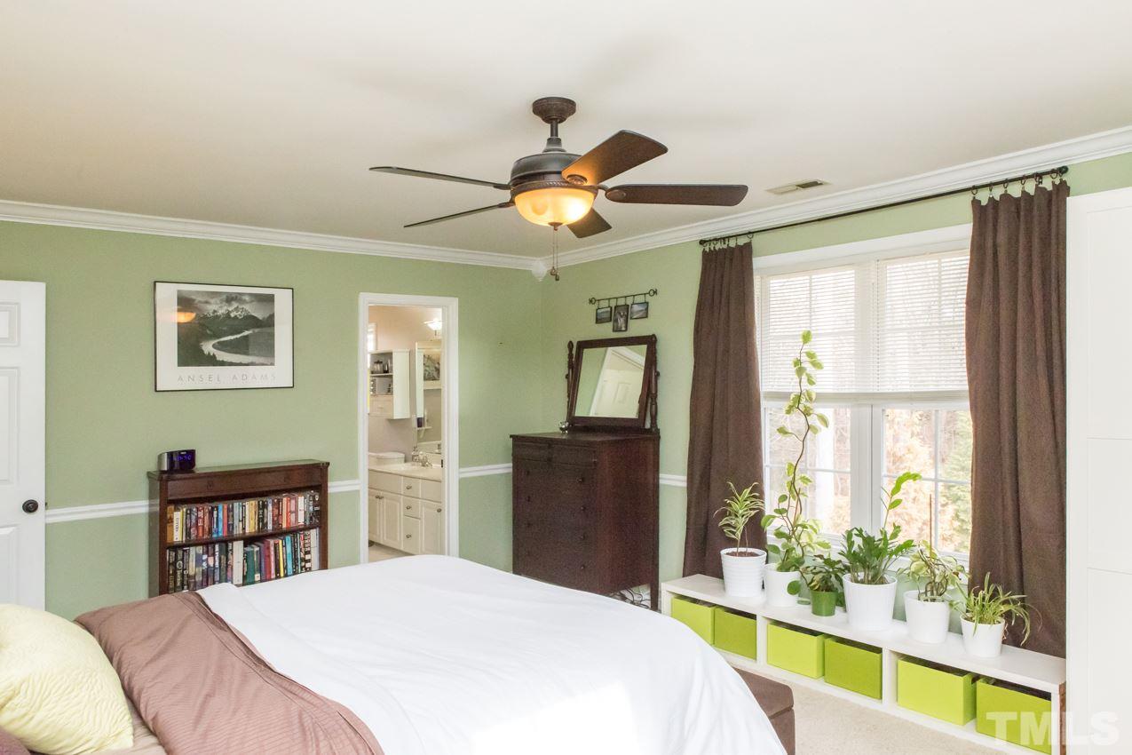 9108 Castleton Lane Raleigh, NC 27615 - Photo 14 of 25 a bedroom with a bed and a chandelier