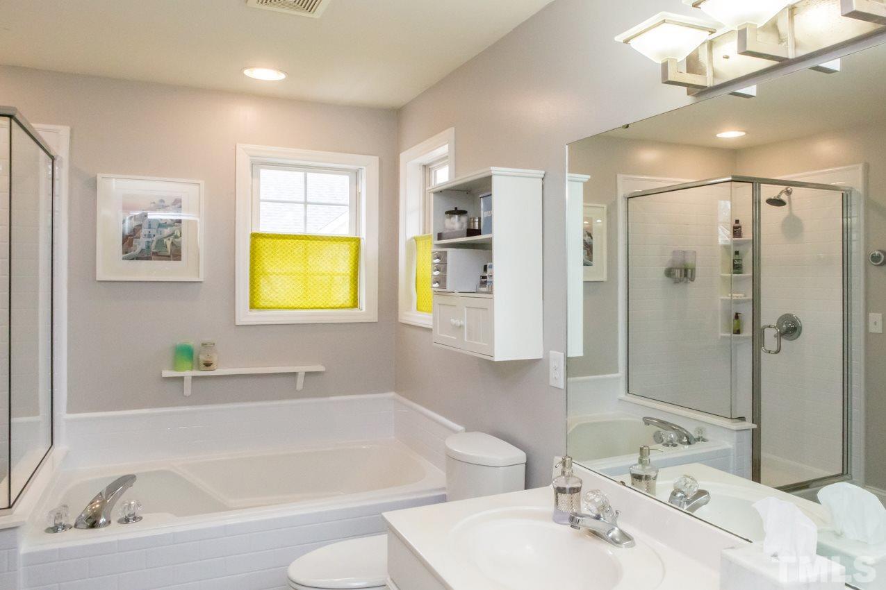 9108 Castleton Lane Raleigh, NC 27615 - Photo 15 of 25 a bathroom with a bathtub sink and a mirror