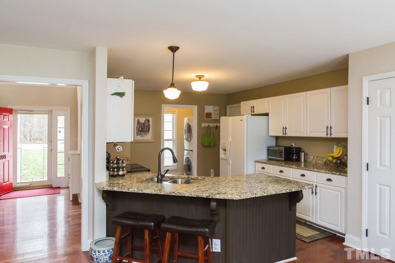 9108 Castleton Lane Raleigh, NC 27615 - Photo 6 of 25 a kitchen with kitchen island a sink stove and refrigerator
