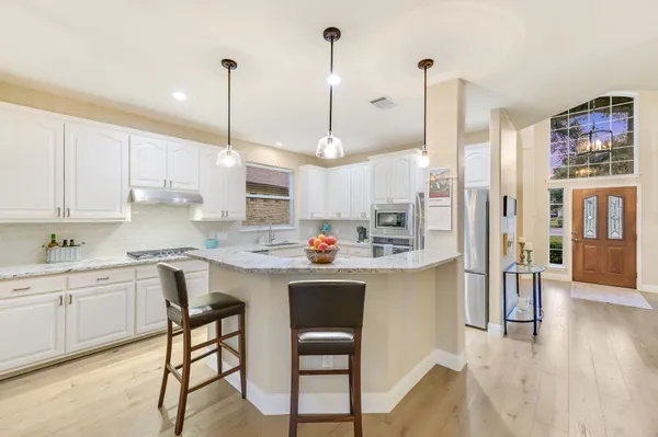a kitchen with kitchen island a stove a table and chairs in it