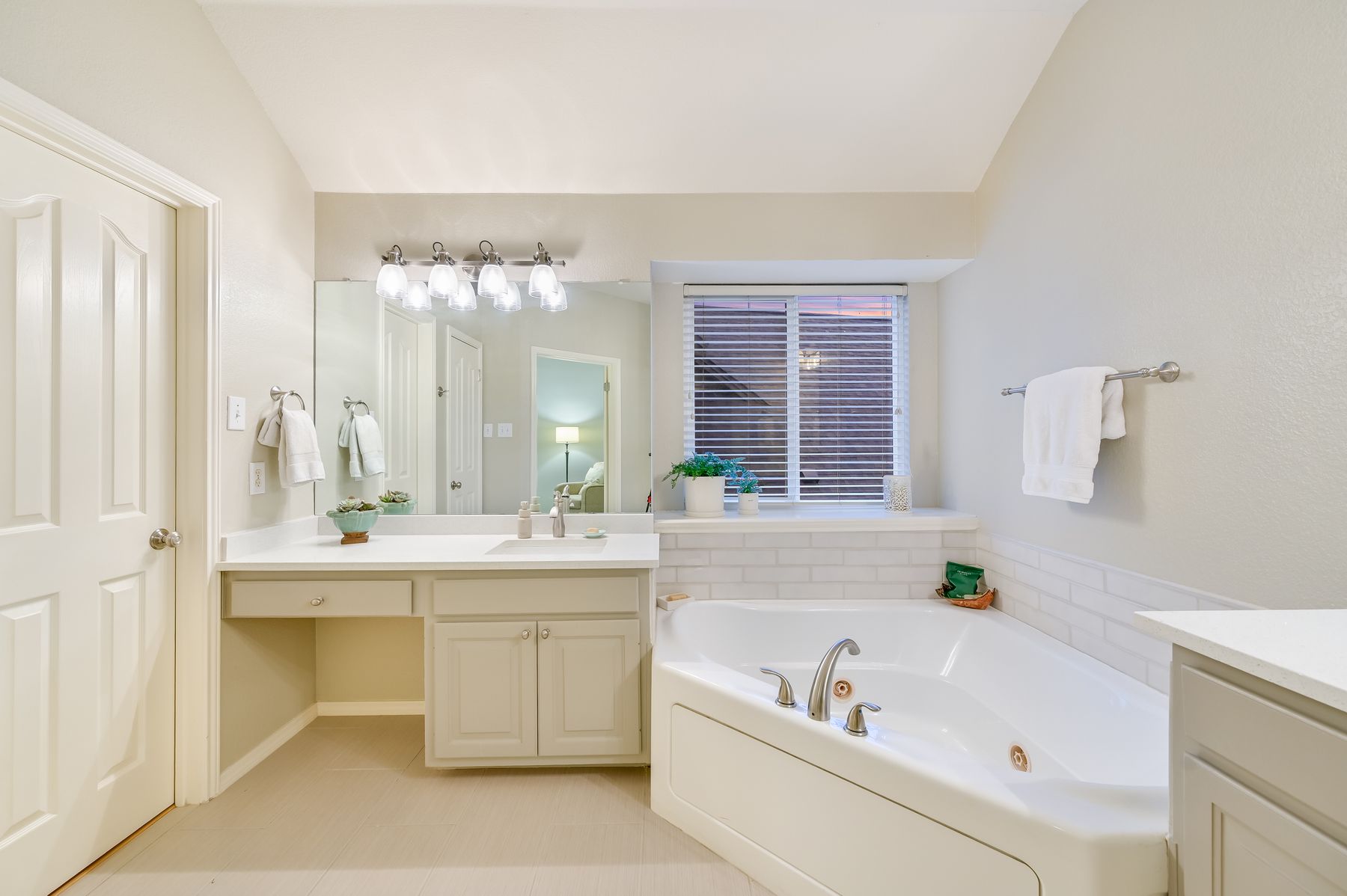 300 River Ridge Drive Georgetown, TX 78628 - Photo 15 of 32 Bathroom with a whirlpool tub, vanity, vaulted ceiling, and light tile patterned floors