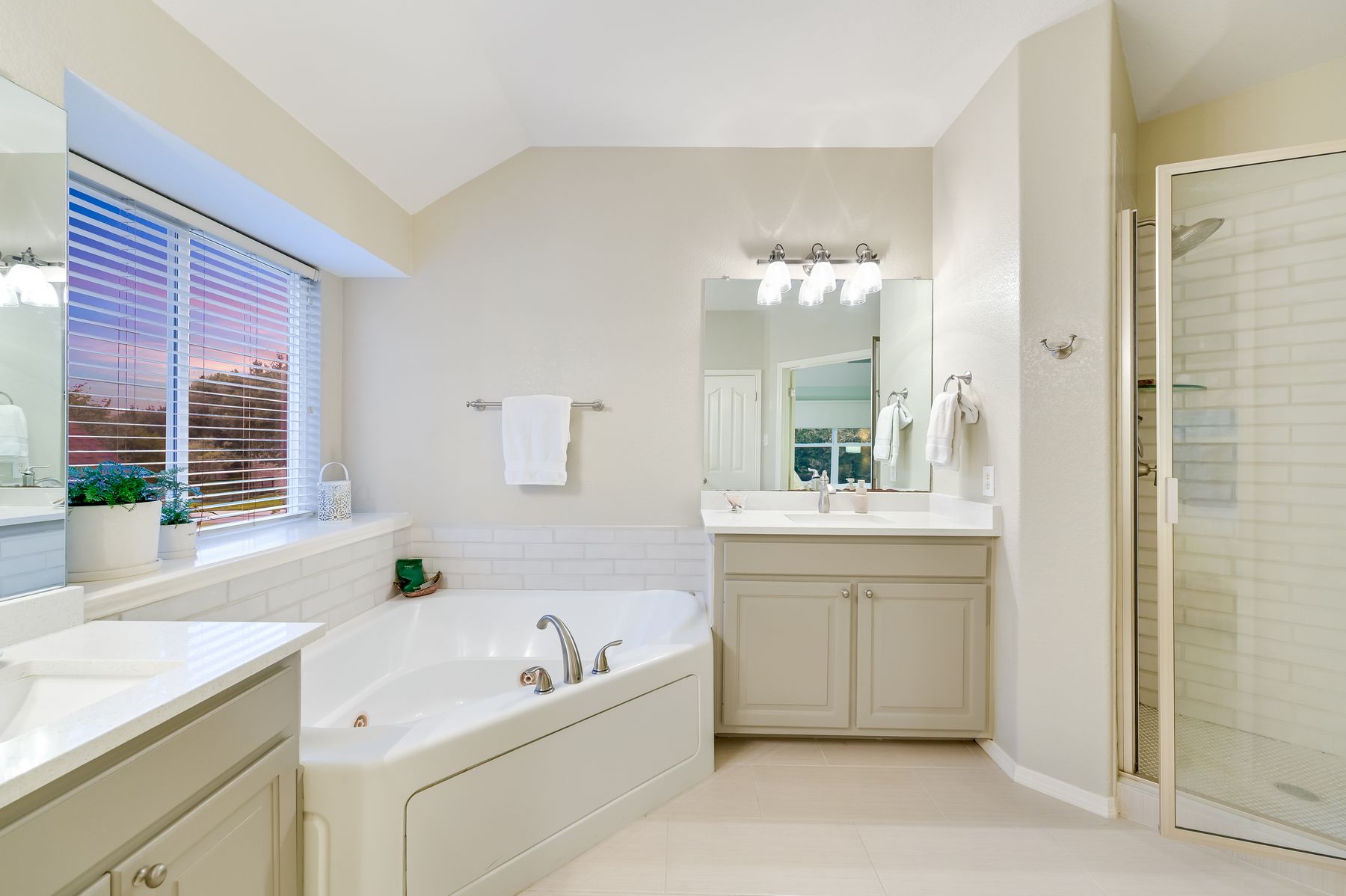 300 River Ridge Drive Georgetown, TX 78628 - Photo 16 of 32 Bathroom with a bath, two vanities, a stall shower, light tile patterned flooring, and lofted ceiling