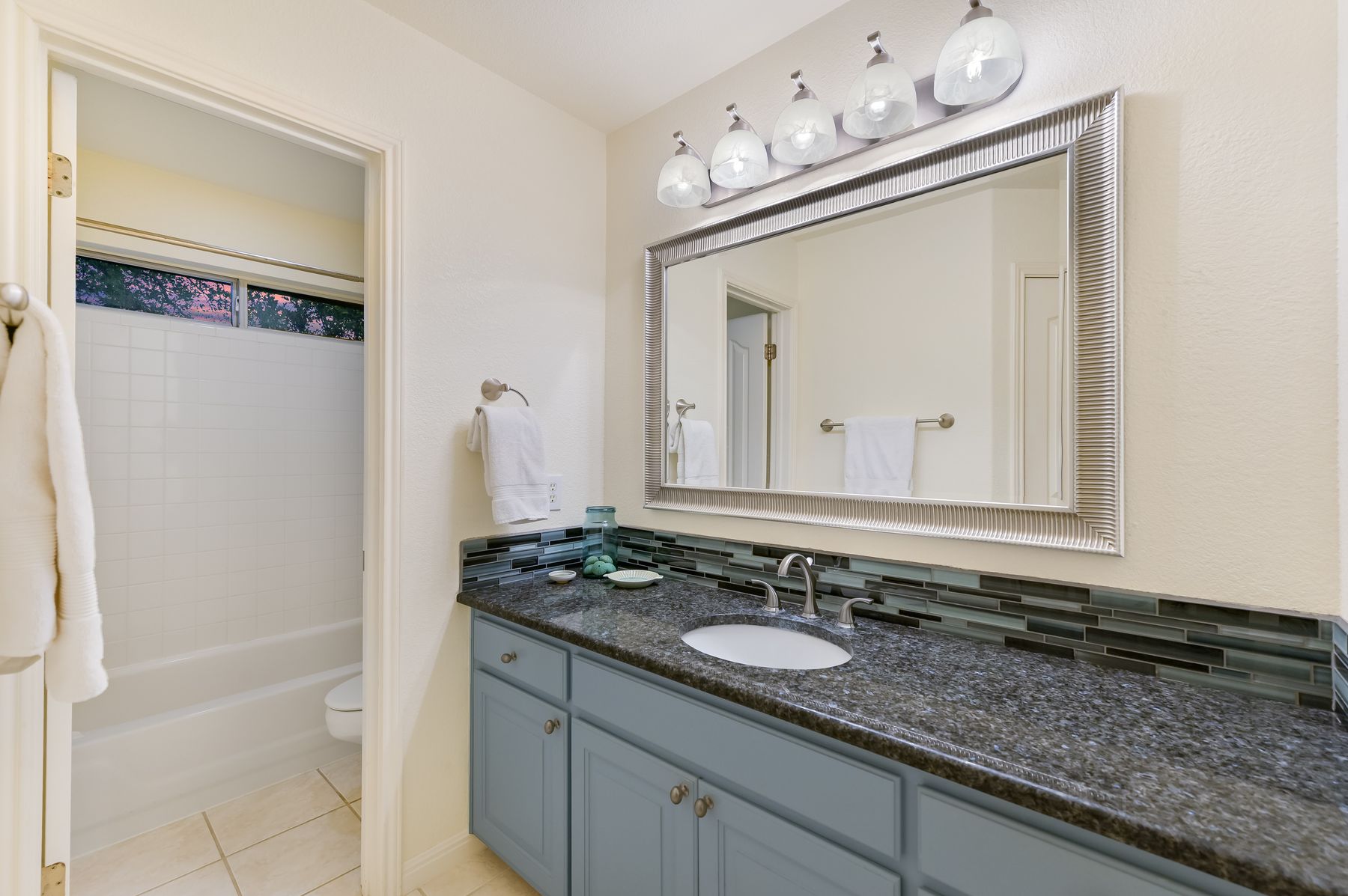 300 River Ridge Drive Georgetown, TX 78628 - Photo 18 of 32 Bathroom with vanity, tasteful backsplash, shower / bath combination with curtain, and light tile patterned flooring