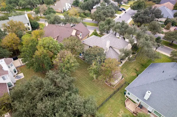 an aerial view of residential houses with outdoor space and parking