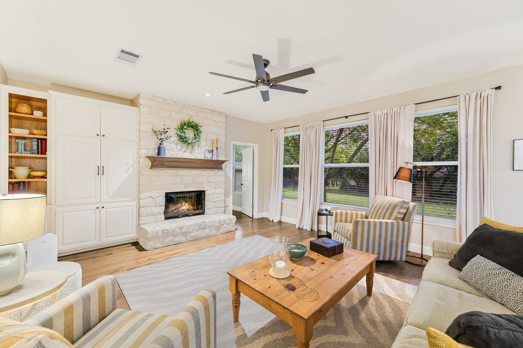 300 River Ridge Drive Georgetown, TX 78628 - Photo 7 of 32 Living area with a stone fireplace, ceiling fan, and light wood finished floors