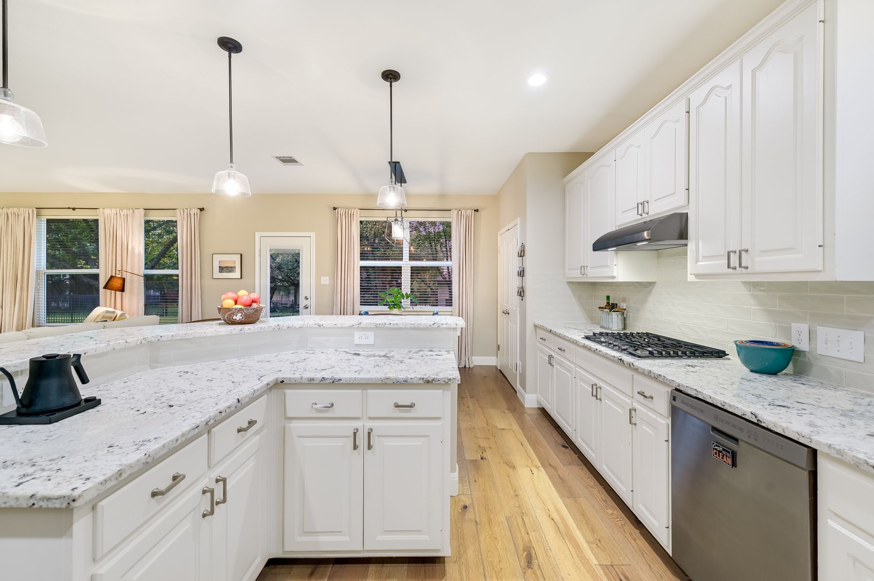 300 River Ridge Drive Georgetown, TX 78628 - Photo 10 of 32 Kitchen featuring decorative light fixtures, white cabinetry, stainless steel appliances, light stone countertops, and recessed lighting