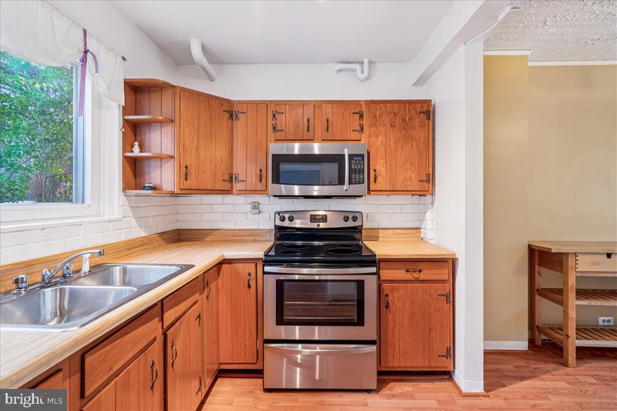 47 Ridge Road Greenbelt, MD 20770 - Photo 12 of 38 a kitchen with granite countertop a stove top oven sink and cabinets