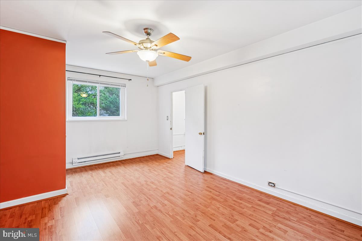 47 Ridge Road Greenbelt, MD 20770 - Photo 22 of 38 an empty room with wooden floor fan and windows