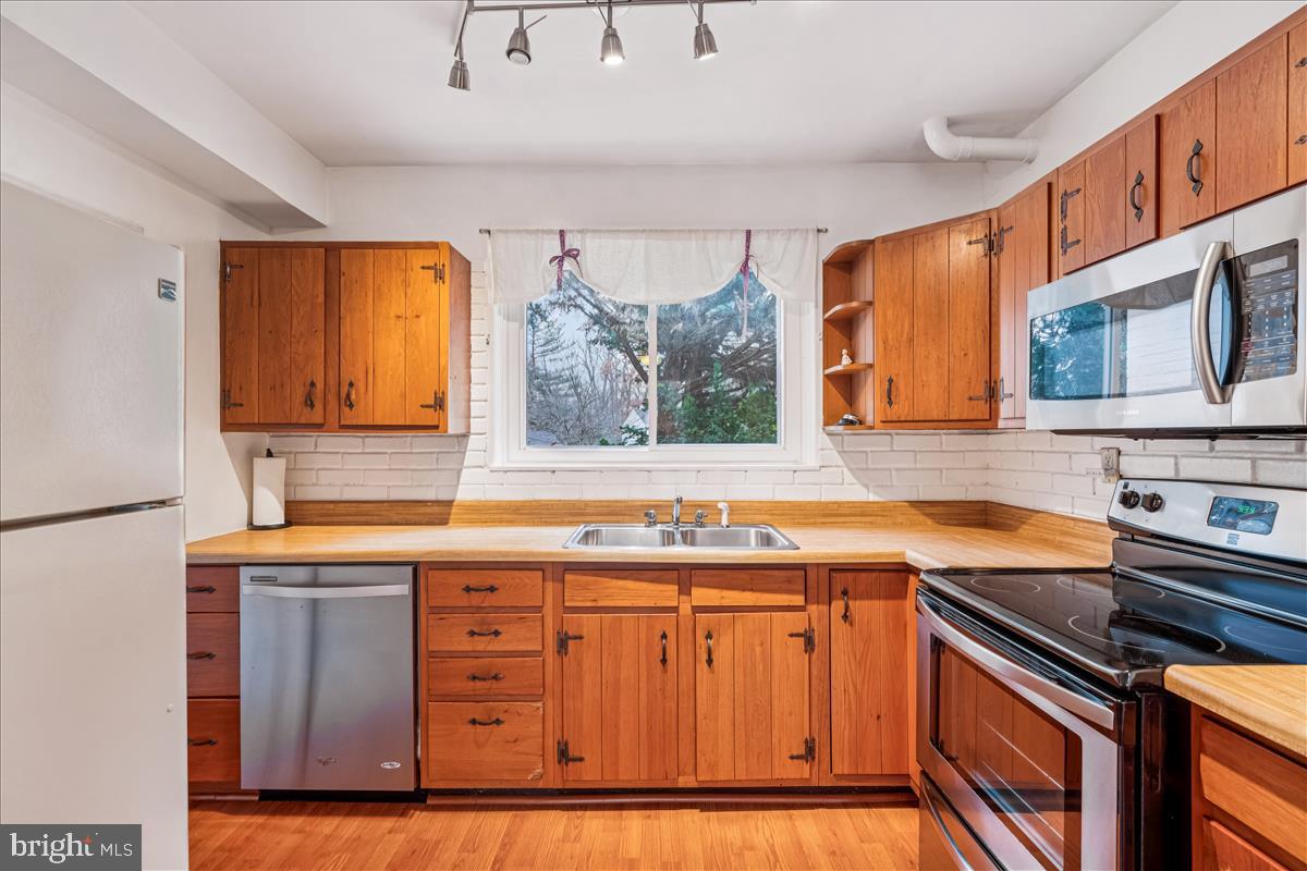 47 Ridge Road Greenbelt, MD 20770 - Photo 10 of 38 a kitchen with stainless steel appliances granite countertop a sink stove and refrigerator