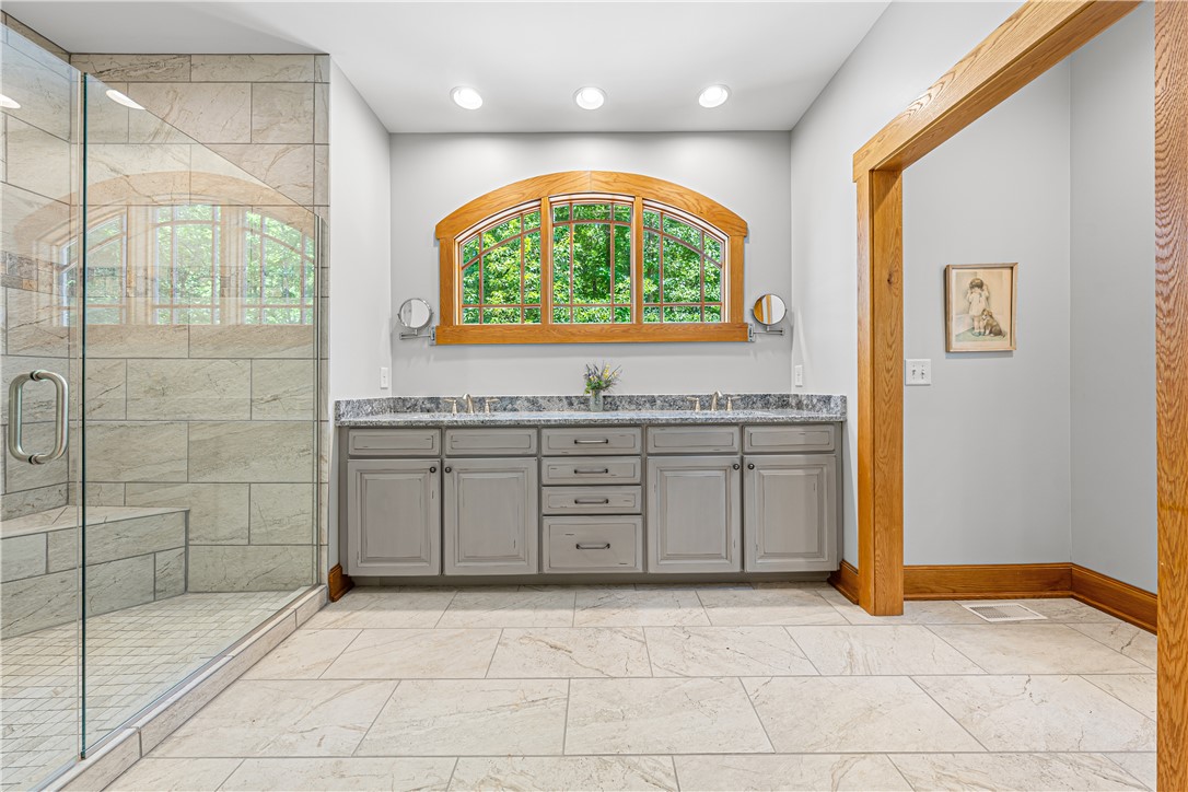 285 Bertha Allen Road Westminster, SC 29693 - Photo 10 of 50 Indulge in a primary bathroom featuring a spacious walk-in shower and dual vanities beneath an arched window.