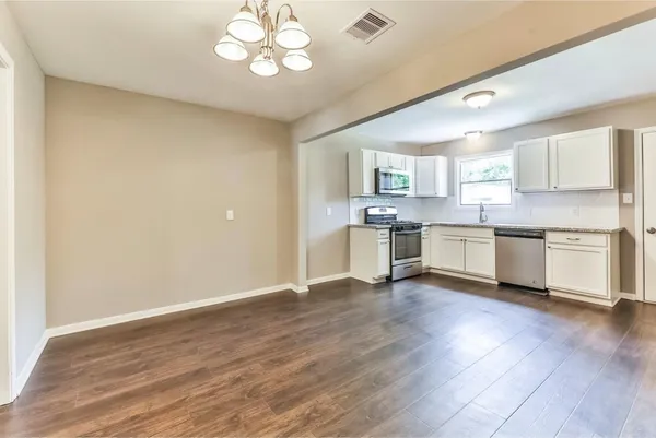 a kitchen with granite countertop white cabinets and stainless steel appliances