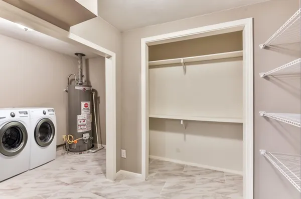 a bedroom with a bed and a lamp on dresser