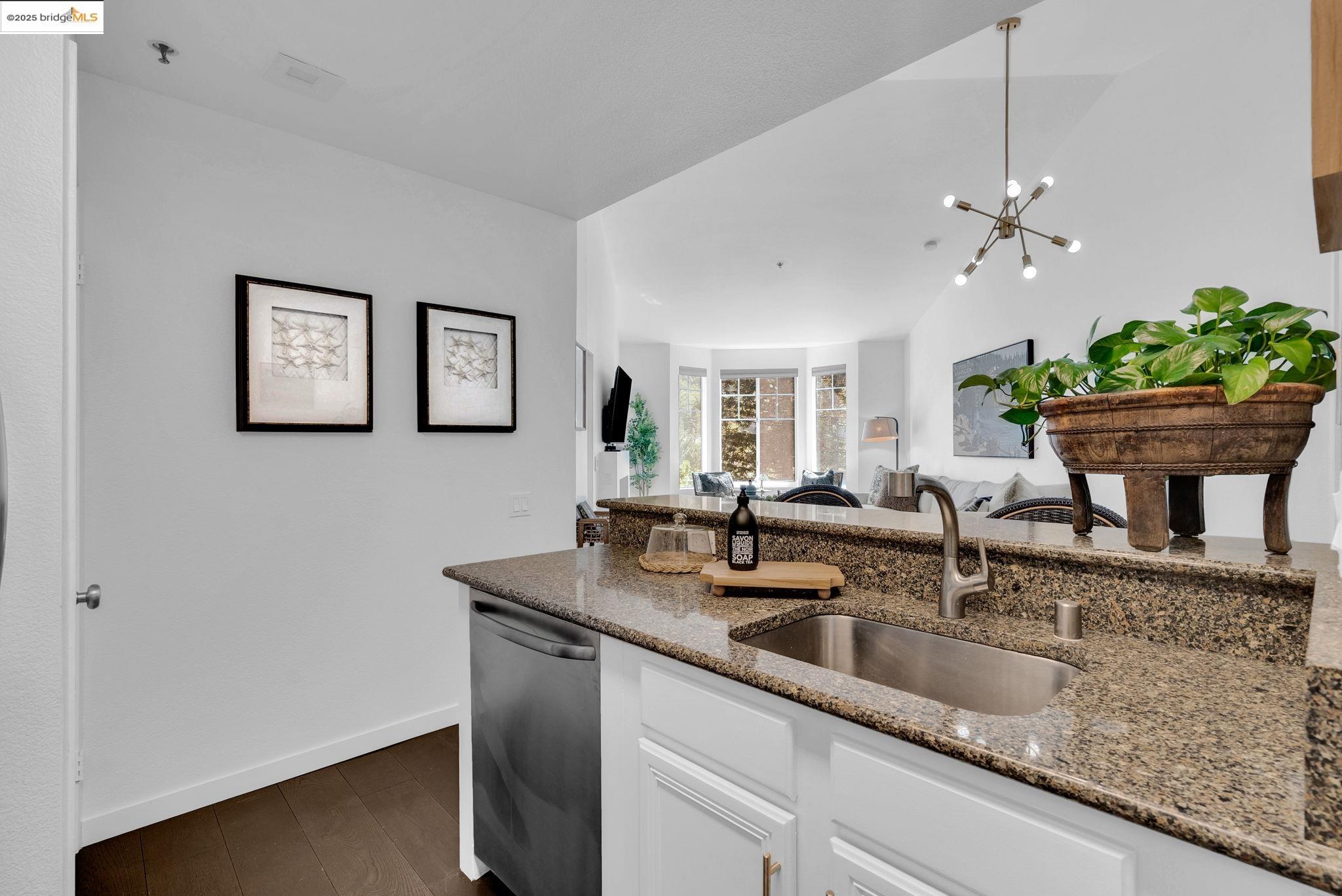 180 Caldecott Lane, Unit U314 Oakland, CA 94618 - Photo 26 of 26 Kitchen featuring white cabinetry, dark stone counters, dark wood-style flooring, dishwasher, and open floor plan