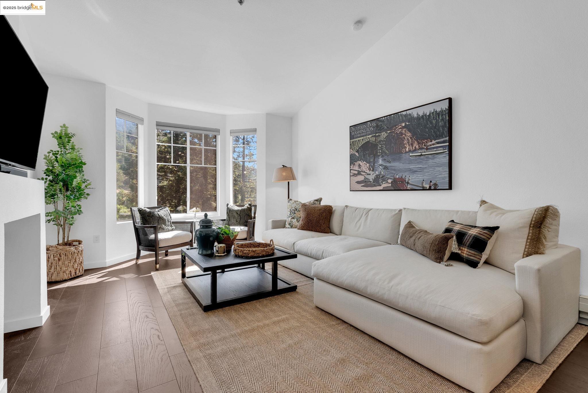 180 Caldecott Lane, Unit U314 Oakland, CA 94618 - Photo 8 of 26 Living room with wood finished floors and baseboards