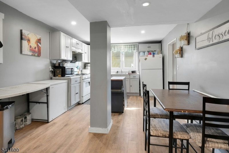 6 Madison Street Newton, NJ 07860 - Photo 12 of 28 a kitchen with stainless steel appliances kitchen island granite countertop a dining table chairs and a refrigerator