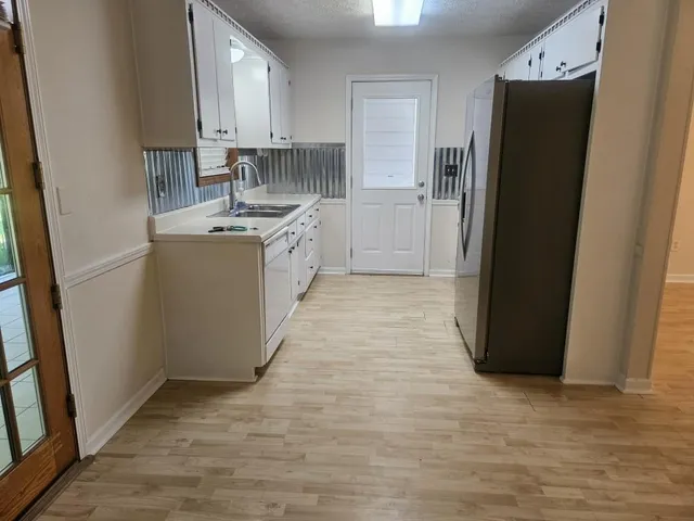 a kitchen with refrigerator and cabinets