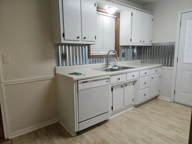 a kitchen with granite countertop white cabinets and sink