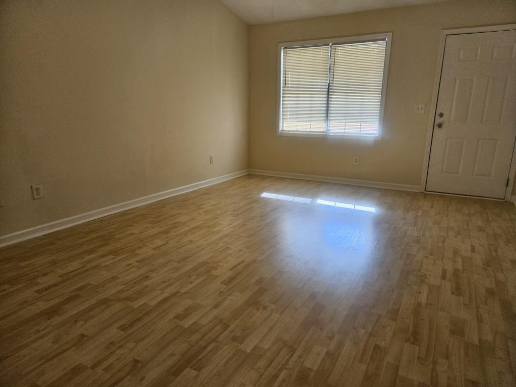 4121 Burgundy Way Flowery Branch, GA 30542 - Photo 7 of 15 an empty room with wooden floor and windows